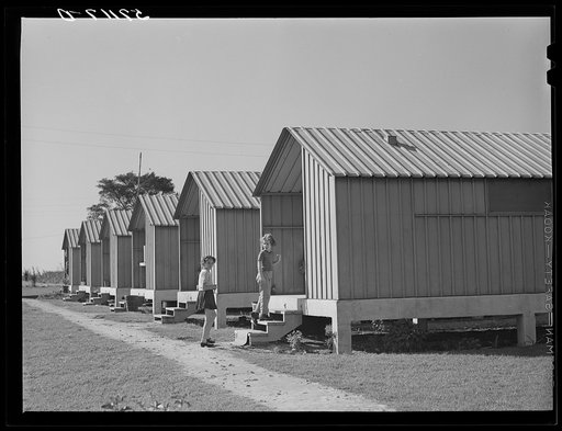 Children of migrant packing house workers in front of metal shelters at Osceola migratory labor camps built by FSA (Farm Security Administration) in Belle Glade, Florida