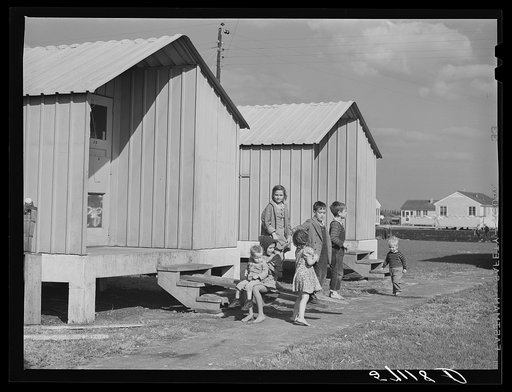 Children of migrant packing house workers in front of metal shelters at Osceola migratory labor camps built by FSA (Farm Security Administration) in Belle Glade, Florida