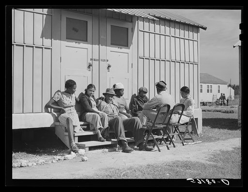 Agricultural workers in front of their metal shelters at Okeechobee migratory labor camp. Belle Glade, Florida