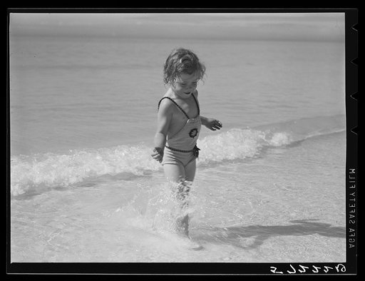 Daughters of guests at Sarasota trailer park, Sarasota, Florida, playing in water before picnic lunch at beach