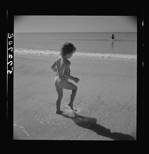 Daughter of parents living at Sarasota trailer park, Sarasota, Florida, playing in the water at the beach