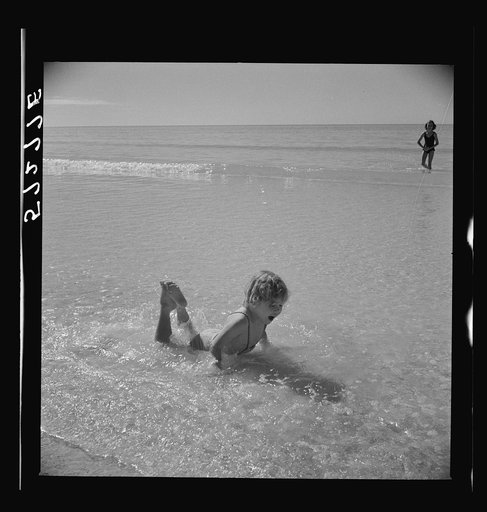 Untitled photo, possibly related to: Daughters of guests at Sarasota trailer park, Sarasota, Florida, playing in water before picnic lunch at beach