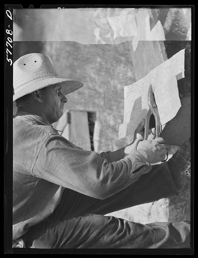 Cutting metal reinforcing for corners. Screen door construction demonstration. Charles County, La Plata, Maryland