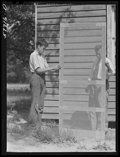 Untitled photo, possibly related to: Door frame with screen wire assembled ready to fasten on hinge strip. Screening demonstration. Charles County, La Plata, Maryland