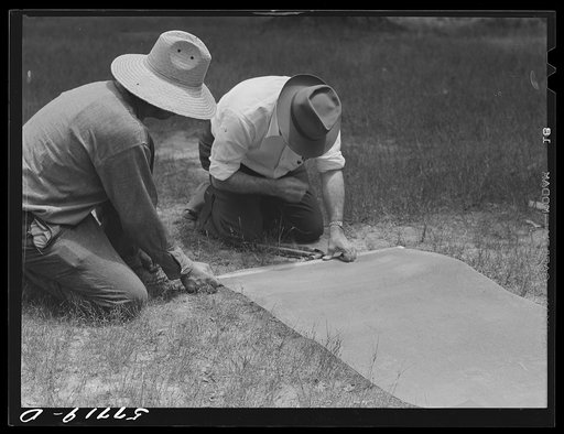 Untitled photo, possibly related to: Fastening 16-mesh galvanized wire screen to battens before applying to open window frame. Screening demonstration. Charles County, La Plata, Maryland