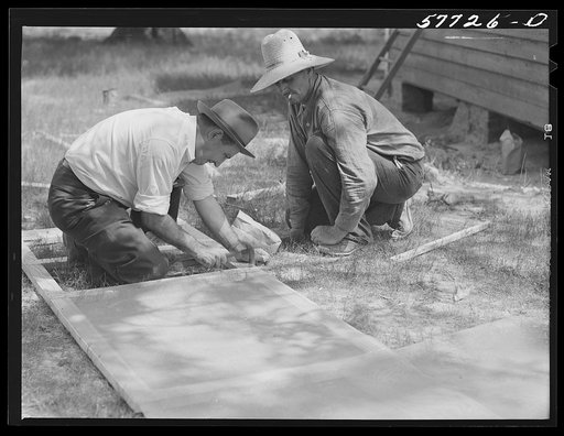 Screen is tacked to inside of frame and inside joints are reinforced. Screen door construction demonstration. Charles County, La Plata, Maryland