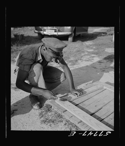 Untitled photo, possibly related to: Nailing metal reinforcement over the screen wire. This is the inside of the door. Nails do not penetrate clear through the stock. Screening demonstration. Saint Mary's County, Ridge, Maryland