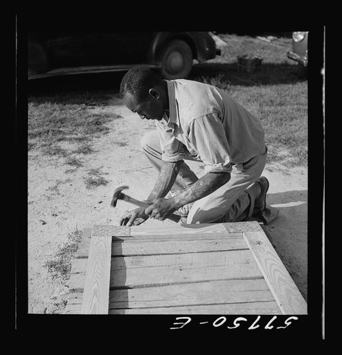 Assembling a joint of screen door. Screen door stock used is one inch by four inches.  Joints are cut square and held together with corrugated fasteners. Screening demonstration. Saint Mary's County, Ridge, Maryland