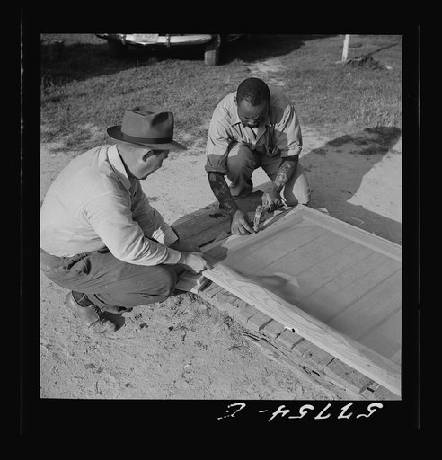 Screen is tacked to top of door first. Demonstration of home screen door construction. Saint Mary's County, Maryland, Ridge