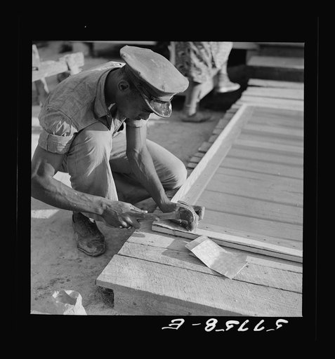 Untitled photo, possibly related to: Nailing metal reinforcement over the screen wire. This is the inside of the door. Nails do not penetrate clear through the stock. Screening demonstration. Saint Mary's County, Ridge, Maryland