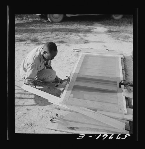 Tacking the mesh galvanized screen wire to back of door frame. Screening demonstration. Saint Mary's County, Ridge, Maryland