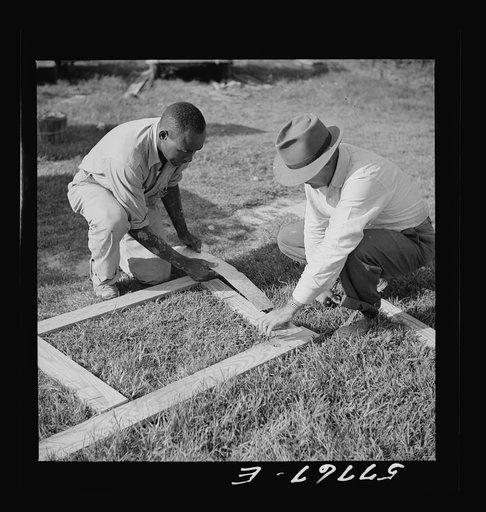 Applying the metal reinforcing over joints. Demonstration of home screen door construction. Saint Mary's County, Ridge, Maryland