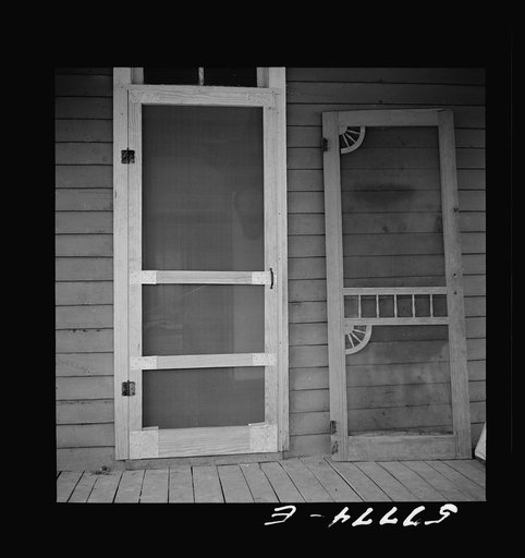 Untitled photo, possibly related to: Door assembled in place alongside old door. Screen door construction demonstration. Charles County, La Plata, Maryland