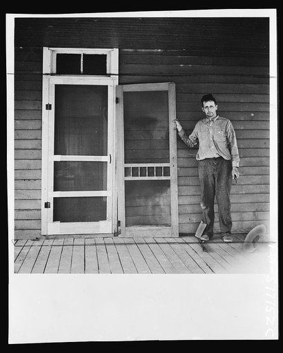 Door assembled in place alongside old door. Screen door construction demonstration. Charles County, La Plata, Maryland