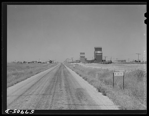 Grain storage elevators and highway through Lone Tree, North Dakota