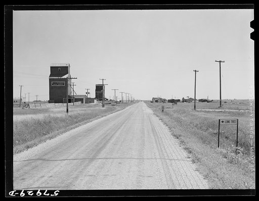 Grain storage elevators and highway through Lone Tree, North Dakota
