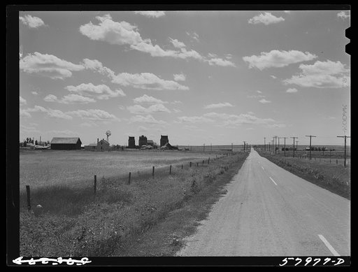 Highway, showing grain elevators and part of town of Froid, Montana