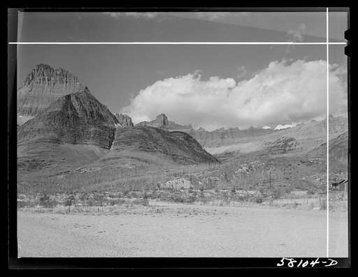 Burnt-over land, evidences of forest fire, rocky wall from Many Glacier highway. Glacier National Park, Montana