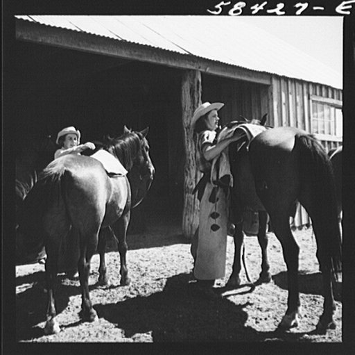 Dudes saddling their horses at Quarter Circle U Ranch, Brewster-Arnold Ranch Company. Birney, Montana