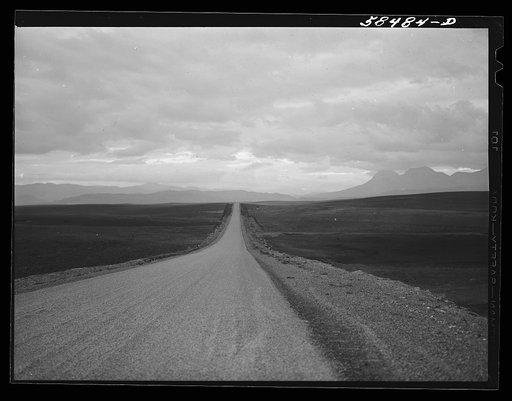 Road to Glacier National Park just after sundown, with storm over the Rocky Mountains in the distance. Montana