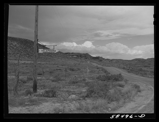Untitled photo, possibly related to: Sign at crossroads pointing direction to nearest telephone in ranch country. Birney, Montana