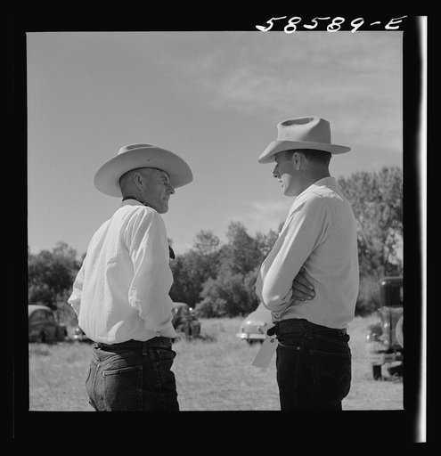 Untitled photo, possibly related to: Lyman Brewster from Quarter Circle U Ranch in Birney, Montana, talking to a neighbor stockman at stockmen's picnic and barbecue. Spear's Siding, Wyola, Montana