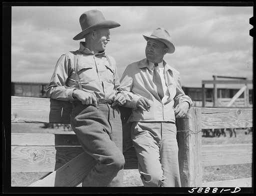 "Doc" Conway, rancher from Craig, Colorado talking to Beckman, commission merchant from Denver stockyards, by livestock pens in Craig, Colorado