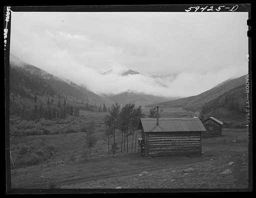 Untitled photo, possibly related to: Cabins on ranch. Mist and clouds over mountains before an early blizzard