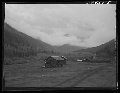 Cabins on ranch. Mist and clouds over mountains before an early blizzard