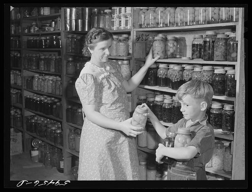 Mrs. Harvey Renninger and son in her home with canned goods. Two River Non-Stock Cooperative, FSA (Farm Security Administration) coop. Waterloo, Nebraska