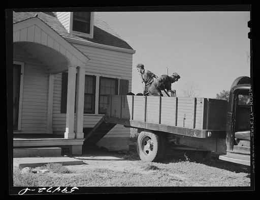 Harvey Renninger with helper, Tony Ringler, delivering coal to one of the families of Two River Non-Stock Cooperative, a FSA (Farm Security Administration) co-op at Waterloo, Nebraska