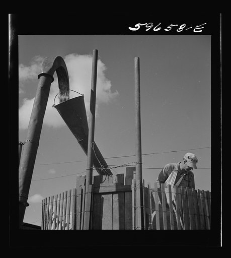 Co-op members filling a home-made silo with corn. Two Rivers Non-Stock Cooperative Company. Waterloo, Nebraska