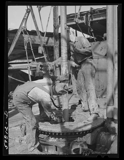 Untitled photo, possibly related to: Oil workers pulling up old pipe to change bit on drilling pipe at bottom of oil well in C.C. Graber pool of Continental oil company. Moundridge area near McPherson, Kansas