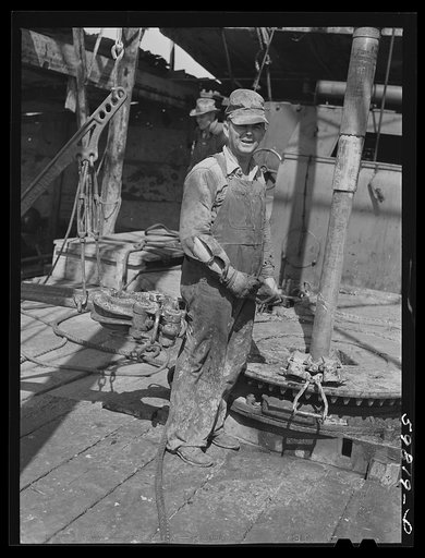 Jim Eckles, water pumper, "backup man" from Kansas. Been in oil field four years, was formerly a farmer and still raises chickens near Moundridge, pulling up old pipe in oil well in C.C. Graber Pool. Continental oil company, Moundridge area near McPherson, Kansas