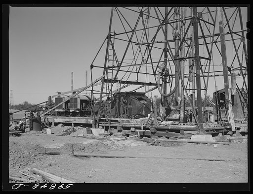 Untitled photo, possibly related to: "Making a trip," pulling up old pipe to change bit on drilling pipe on the bottom of oil well at C.C. Graber pool of Continental oil company. Moundridge area near McPherson, Kansas