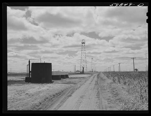 Oil well derricks and oil tanks in Moundridge area near McPherson, Kansas