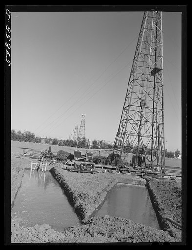 Untitled photo, possibly related to: "Making a trip," pulling up old pipe to change bit on drilling pipe on the bottom of oil well at C.C. Graber pool of Continental oil company. Moundridge area near McPherson, Kansas