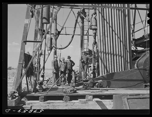 "Making a trip," pulling up old pipe to change bit on drilling pipe on the bottom of oil well at C.C. Graber pool of Continental oil company. Moundridge area near McPherson, Kansas