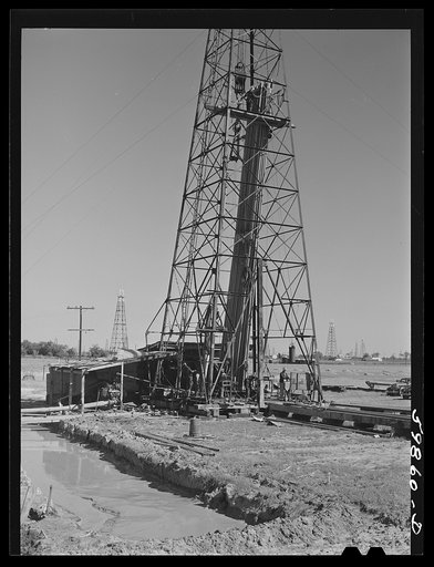 "Making a trip," pulling up old pipe to change bit on drilling pipe on the bottom of oil well at C.C. Graber pool of Continental oil company. Moundridge area near McPherson, Kansas