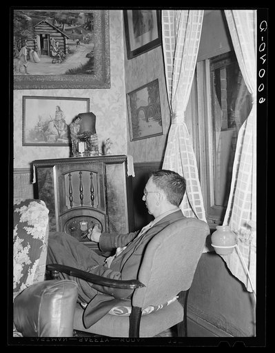 Man listening to radio in hotel lobby. Del Monte Hotel, Elkins, West Virginia