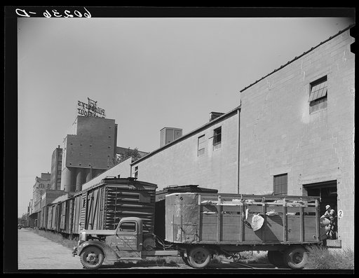 Truck loading up with cattle feed at Pillsbury flour mill. Minneapolis, Minnesota