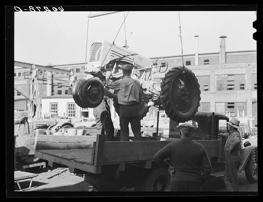 Loading tractor onto truck with crane. Minneapolis, Minnesota