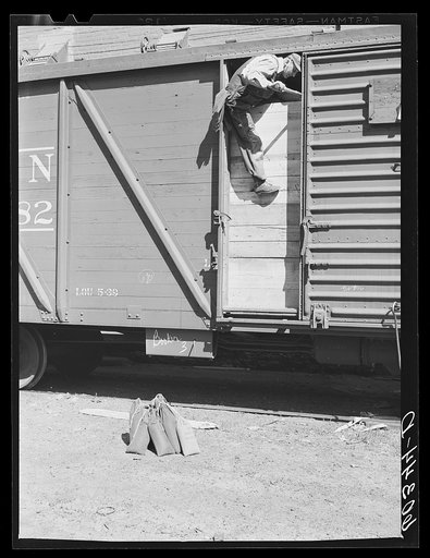 Grain sampler entering car of wheat for samples. He usually gets grain from six different parts of the car. Minneapolis, Minnesota