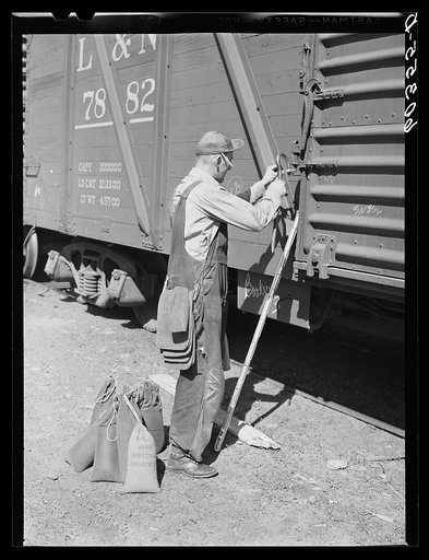 Grain sampler breaking the seal on a carload of wheat. Minneapolis, Minnesota