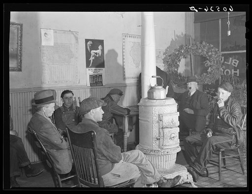 Men sitting around the stove in lobby of thirty-five cents a night hotel. Many of these men are transient men (farm laborers) who quarter here during the winter. Dubuque, Iowa