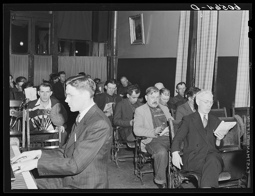 Hymn singing during evening services at city mission for homeless men. Dubuque, Iowa
