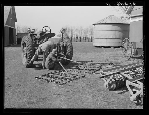 Fred Coulter's hired men attaching spike tooth harrow to tractor. Grundy County, Iowa