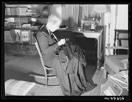 Wife of Iowa corn farmer sewing choir robes for Methodist church. Greene County, Iowa