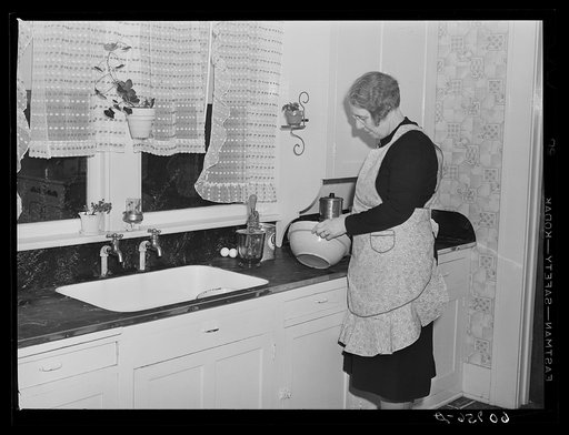 Wife of Iowa farmer starting to make a cake. Greene County, Iowa