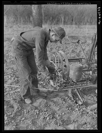 Adjusting wire on corn planter. Monona County, Iowa